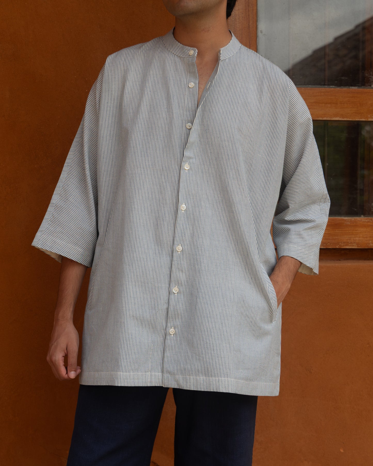 Organic cotton kimono shirt for men in light capri blue stripes, crafted from handspun, handwoven khadi with a modern Japanese silhouette.