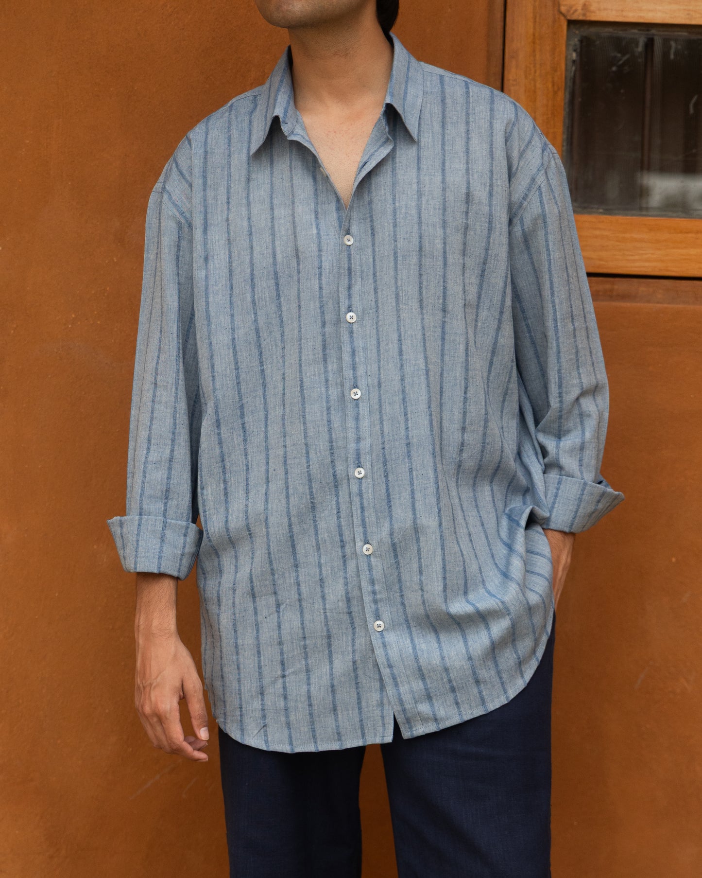 Handspun and handwoven indigo shirt for men, made from breathable organic cotton with a loose, comfortable silhouette.