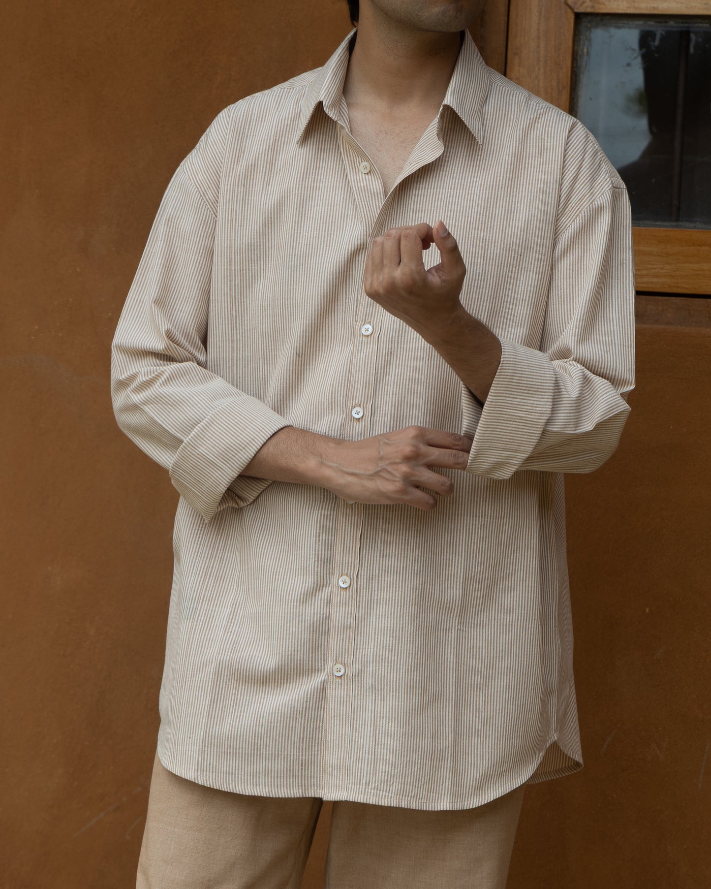 Earthy-toned khadi cotton shirt for men featuring brown and beige stripes, relaxed silhouette, and traditional handloom texture.