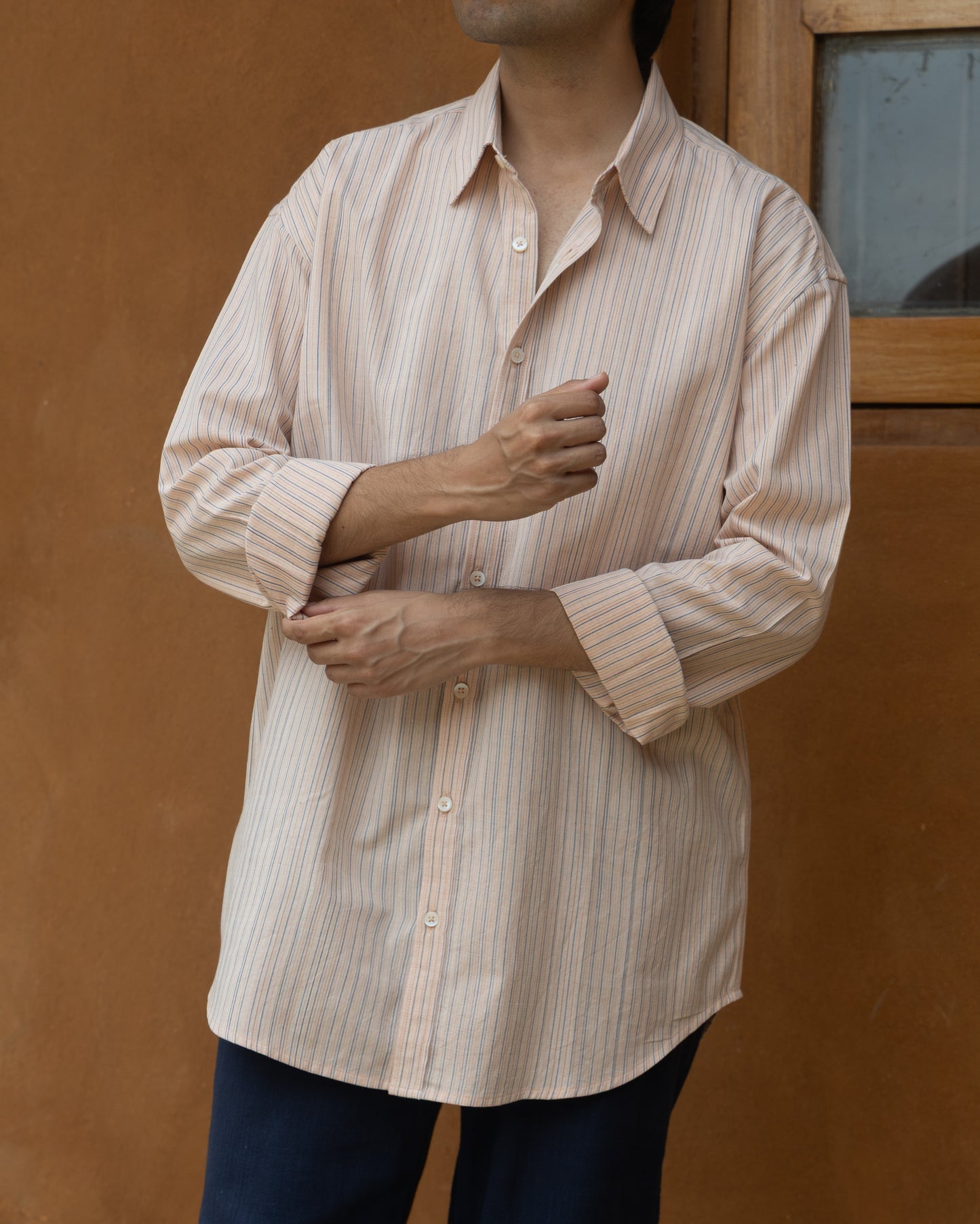Handwoven khadi shirt for men in soft pastel pink with multi-color stripes, crafted from sustainable, organic cotton.