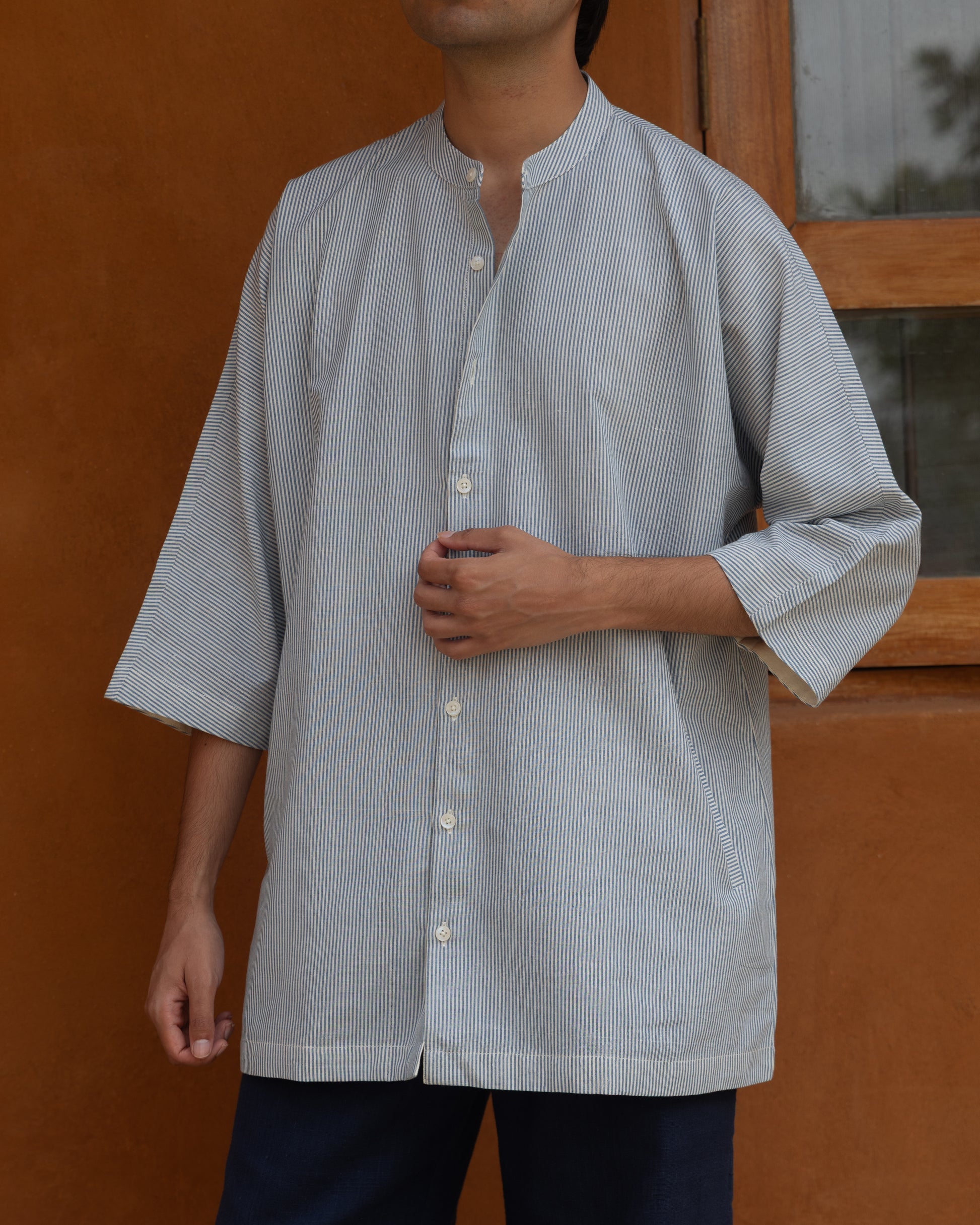 Men’s pastel blue handwoven khadi shirt featuring a relaxed kimono-style cut with 3/4 sleeves and eco-friendly fabric.